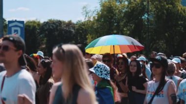 Varşova, Polonya 25.06.2022 eşitlik geçit töreni insanları LGBT sembolleriyle cadde boyunca yürüyorlar, elinde gökkuşağı şemsiyesi olan bir kadın. Yüksek kalite 4k görüntü