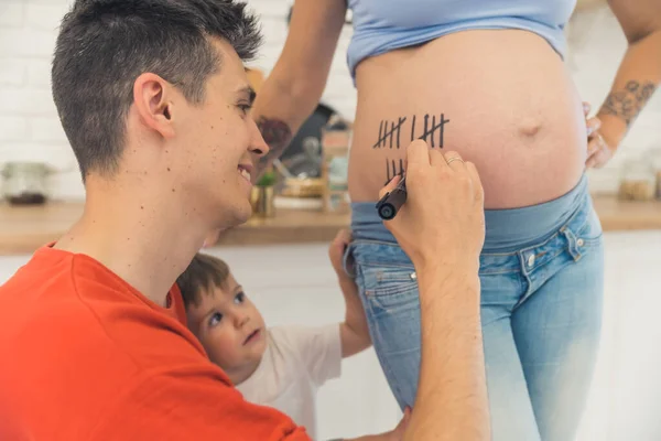 Man Writing Lines His Wife Belly Counting Pregnancy Weeks Family — Stockfoto