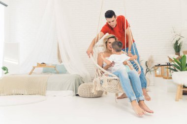 young Caucasian parents relaxing with their kid at home, full shot happy family relationship. High quality photo