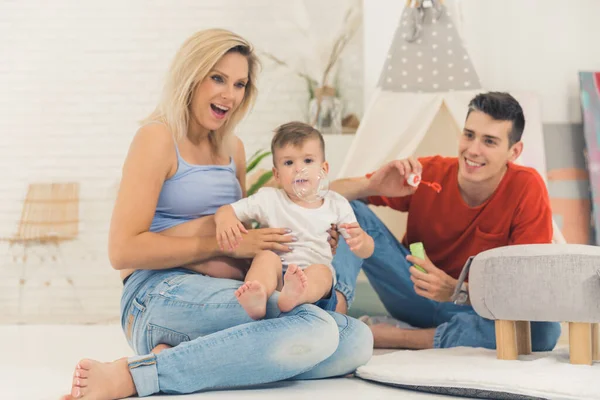 Happy Caucasian Family Playing Soap Bubbles Living Room Full Shot — Stock fotografie