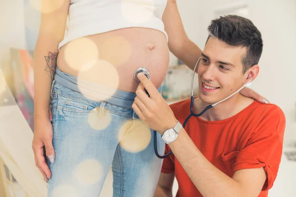 Koca Hamile Karısının Karnındaki Bebek Sesini Dinlemek Için Steteskop Kullanıyor — Stok fotoğraf