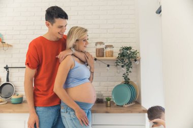 Genç, beyaz bir adam mutfakta güzel karısına sarılıyor. Mutlu aile ilişkisi konsepti orta boy. Yüksek kalite fotoğraf