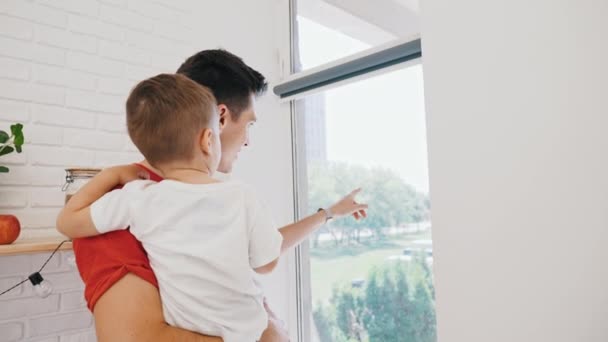 Young Caucasian Man Watching Something Window His Little Son Medium — Stock videók