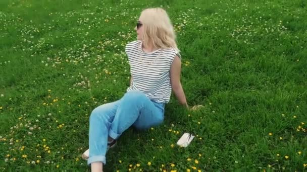 Blond Caucasian Girl Resting Green Grass Looking Medium Full Shot — Wideo stockowe