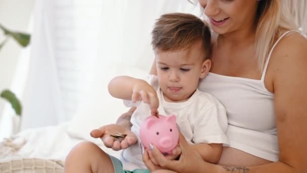 Anne Küçük Oğluna Kumbarada Para Biriktirmeyi Öğretiyor Yüksek Kalite Görüntü — Stok video