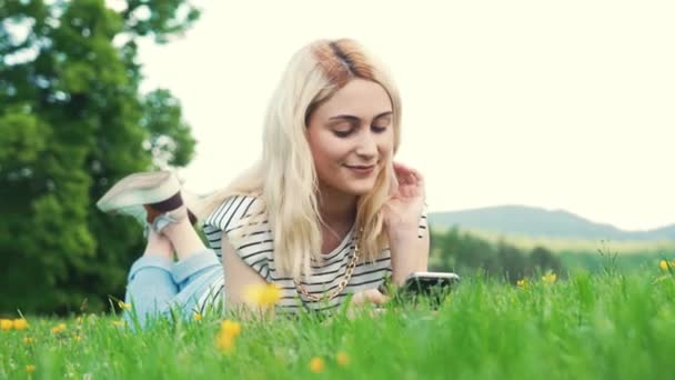 Jong Europees Meisje Liggend Het Gras Typen Haar Telefoon Volle — Stockvideo