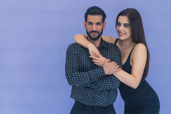 Siyah desenli gömlekli yakışıklı, kendine güvenen sakallı Kübalı adam uzun saçlı, beyaz bir kız tarafından tutuluyor. Destekleyici arkadaşlar ya da ortaklar. Yüksek kalite fotoğraf