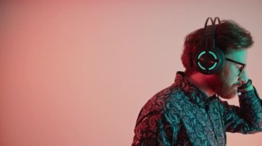 Professional bearded man wearing the headset and shirt listening cerrefully - side profile medium close up - studio. High quality 4k footage