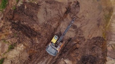 Bir inşaat alanında çalışırken kahverengi bir kumda çukur kazan sarı ve siyah bir endüstriyel makine. Yüksek kalite 4k görüntü