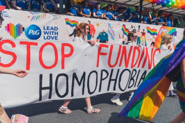 Stop funding homophobia. Big white banner held by Equality Parade participants who are fighting for LGBTQAI rights. High quality photo