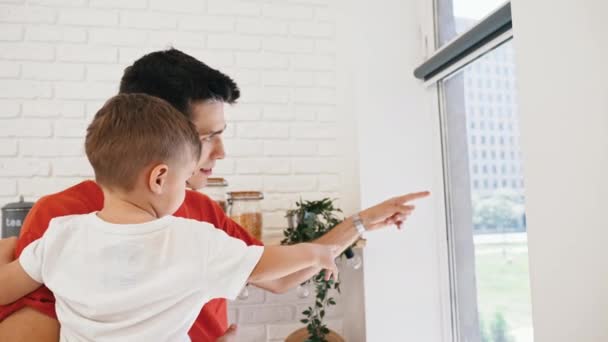 Young Man His Little Son Pointing Out Window Medium Closeup — Stockvideo