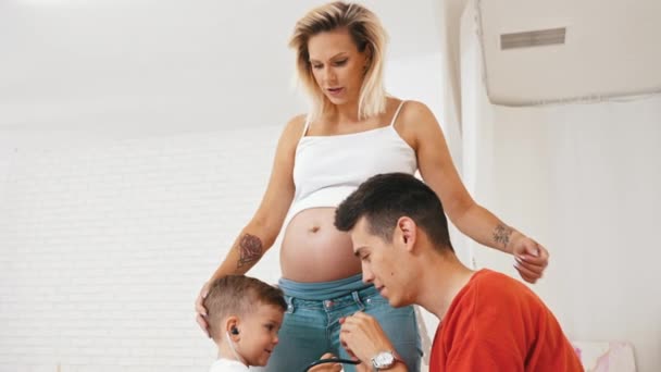 Little Boy His Dad Trying Listen Heartbeat Pregnant Womans Belly — Vídeo de Stock