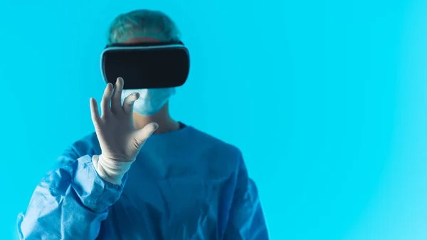 Doctor with virtual reality headset - medium studio shot closeup blue background . High quality photo