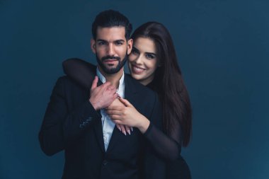 Profesyonel olarak giyinmiş, koyu renk saçlı, kucaklaşan güzel bir çift. Orta boy fotokopi stüdyosu. Genç girişimciler var. Yüksek kalite fotoğraf