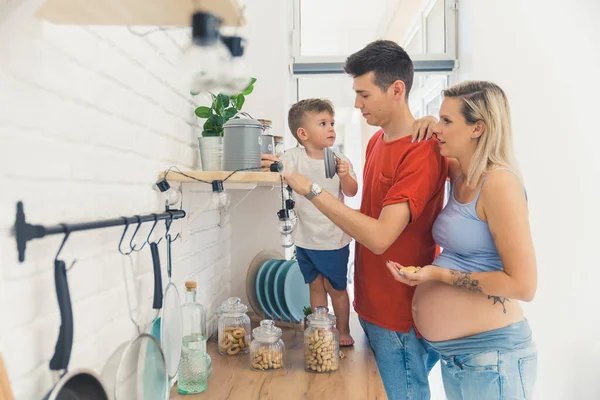 Happy Family Kitchen Pregnant Woman Her Partner Showing Kindergarten Son — Stock fotografie