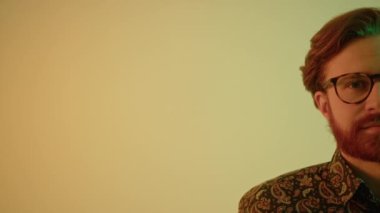 Yüzünün yarısı, genç, şık, sakallı, kızıl saçlı adam kameraya gülümsüyor. Yüksek kalite 4k görüntü