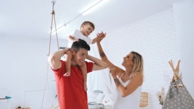 Sırt sırta eğlence. Genç evli çift, küçük oğluyla eğleniyor. Mutlu çocukluk kavramı. Yüksek kalite 4k görüntü