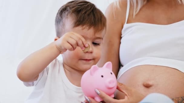 Little Caucasian Boy Focused Carefully Putting Coins His Piggy Bank — Αρχείο Βίντεο