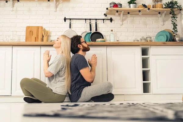 Young Caucasian Couple Kitchen Doing Yoga Prayer Pose Blonde Woman — Stockfoto