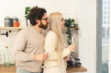 Sakallı, gözlüklü, sarışın kadını kucaklayan, camdan bakan genç, beyaz bir çift. Kapalı çekim. Yüksek kalite fotoğraf