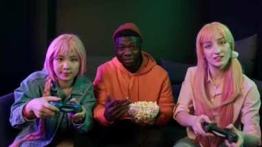 Arkadaşlar oyun oynuyorlar joysticklerle orta boy esport konsepti neon ışıklar kapalı mekanda. Yüksek kalite 4k görüntü