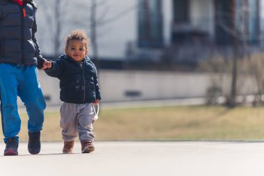 Small Afro American boy walking outside with his friend. High quality photo