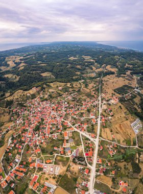 Paliouri Kassandra 'nın dikey drone görüntüsü. Turuncu çatıları ve güzel ufku olan, beyazlatılmış Yunan evleri. Bulutlu gökyüzü. Yüksek kalite fotoğraf