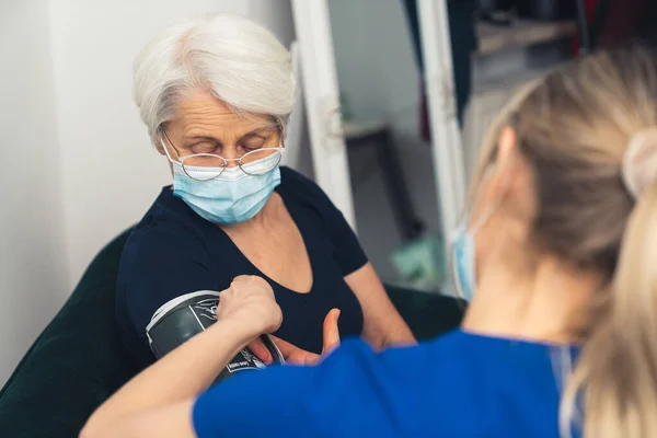 Female Doctor Dark Blue Uniform Checking Blood Pressure Old Lady — Φωτογραφία Αρχείου