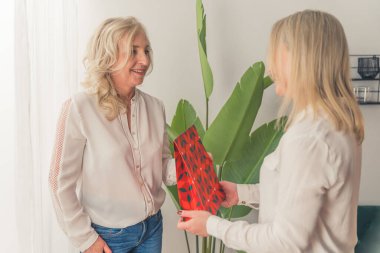 Sarışın kadın ev içi tatil konsepti için orta boy sevgilisinin hediyesine şaşırdı. Yüksek kalite fotoğraf