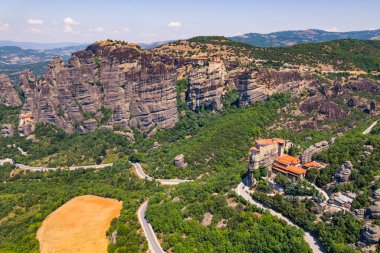 Monastery with red rooftops and a group of huge rocks near Kalabaka town at Meteora. Aerial perspective. High quality photo
