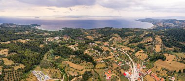 Kassandra Yarımadası 'nın muhteşem panoramik manzarası. Deniz kıyısı, yeşil alanlar, turuncu çatılı geleneksel Yunan evleri. Yüksek kalite fotoğraf