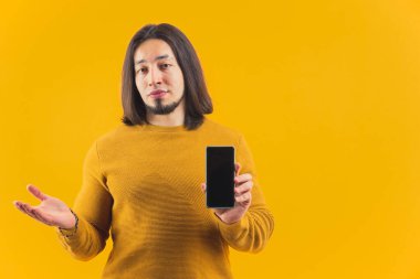 30 'lu yaşlarında izole edilmiş bir Avrupalı stüdyoda telefonunun ekranını gösteriyor. Yüksek kalite fotoğraf