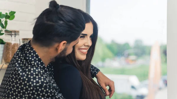 Man Dark Hair Bun Embracing His Wife Smiling Standing Kitchen — Stockfoto