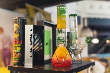 05.28.2022 Warsaw, Poland. One of many was of taking medical marijuana. Colourful glass bongs standing on a black shelf. Alternative medicine. High quality photo