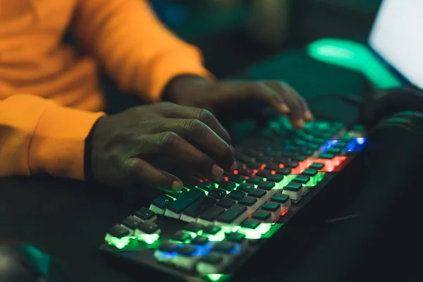 Black Man Orange Sweatshirt Typing Rainbow Colored Professional Gamimng Keyboard —  Fotos de Stock