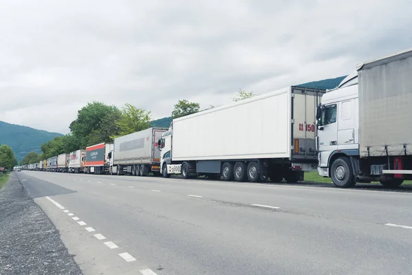 Endless line of transporting trucks standing one after another and waiting on the boarder for a permission for entrance for another country. High quality photo