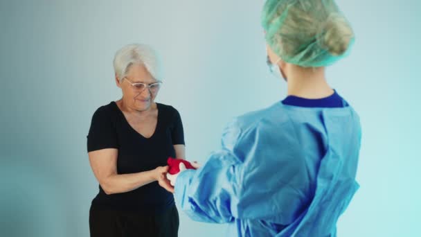 Happy Elderly European Woman Surgeon Doctor Medical Protective Clothes Holding — Stockvideo