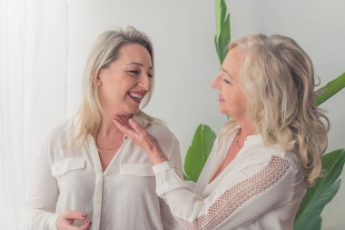 attractive blonde women embracing each other and having a good time together medium shot indoors emotions and love concept. High quality photo