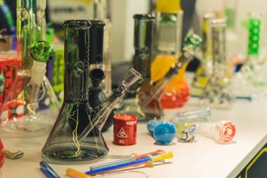 05.28.2022 Warsaw, Poland. Indoor shot of colourful glass bongs in different sizes and smoking pipes. Smoking CBD as an alternative to traditional chemical medicine. High quality photo
