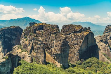 Meteora 'nın doğal olarak güzel kaya oluşumları, ünlü Yunan manastırları. Kahverengi renk çeşitleri. Altında yeşil ormanlar var. Yüksek kalite fotoğraf