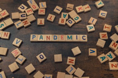 Renkli ahşap harf bulmacaları kullanarak PANDEMIC 'in sembolik tasviri bu kelimeyi yaratıyor. Post-covid dünya kavramı. Ekonomi. Yüksek kalite fotoğraf