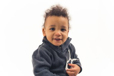Small afro american 5 years old boy holding a skeleton mask and looking at the camera - closeup isolated. High quality photo