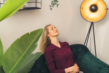 İnce, beyaz bir kadın, kamuflajlı bir kanepede dinleniyor. Yüksek kalite fotoğraf