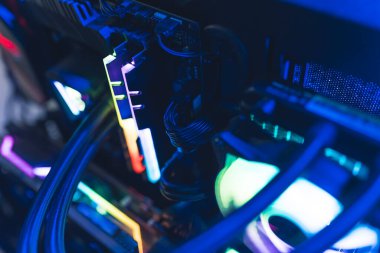 Inside of professional gaming computer with glowing parts in rainbow colors. Dark blue lighting. High quality photo