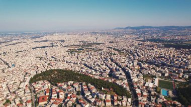 Numerous white-washed Greek houses with orange roof slates seen from birds eye perspective. Beautiful summer weather. High quality photo