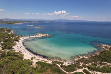Gorgeous photogenic Karydi beach in Greece. Amazing color of water - turquoise and dark blue - white sand and relaxing tourists. High quality photo