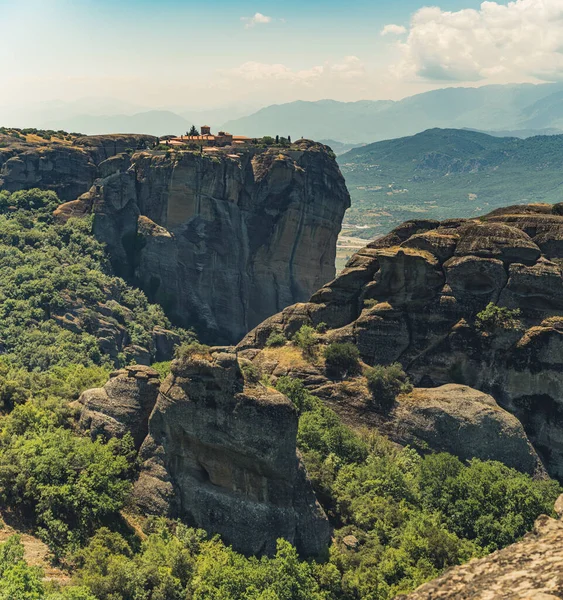 Natural environment and humans. Monks and monasteries. One of the Meteora rock formations. Sunny weather. High quality photo