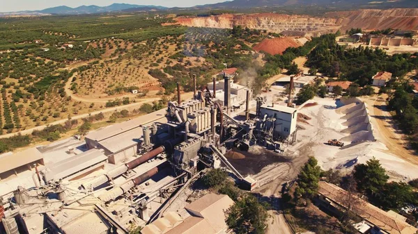 Environment pollution concept. Factory with chimneys in an open pit mine in Greece. Aerial perspective. High quality photo