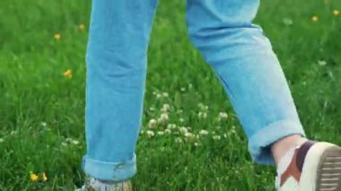 closeup view of girl legs walking on the green grass. High quality 4k footage