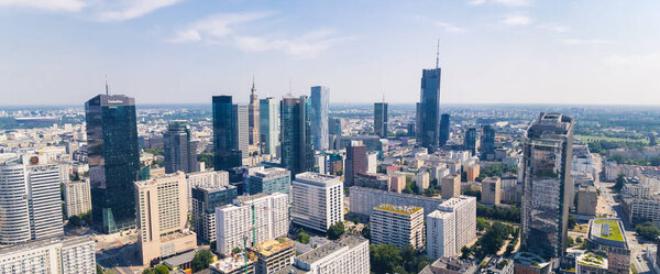 7.22.2022 Warsaw, Poland. Wide panoramic drone shot. Variety of skyscrapers in Warsaw skyline. Social realism represented by Palace of Culture and Science blocked out by neomodern skyscrapers. High